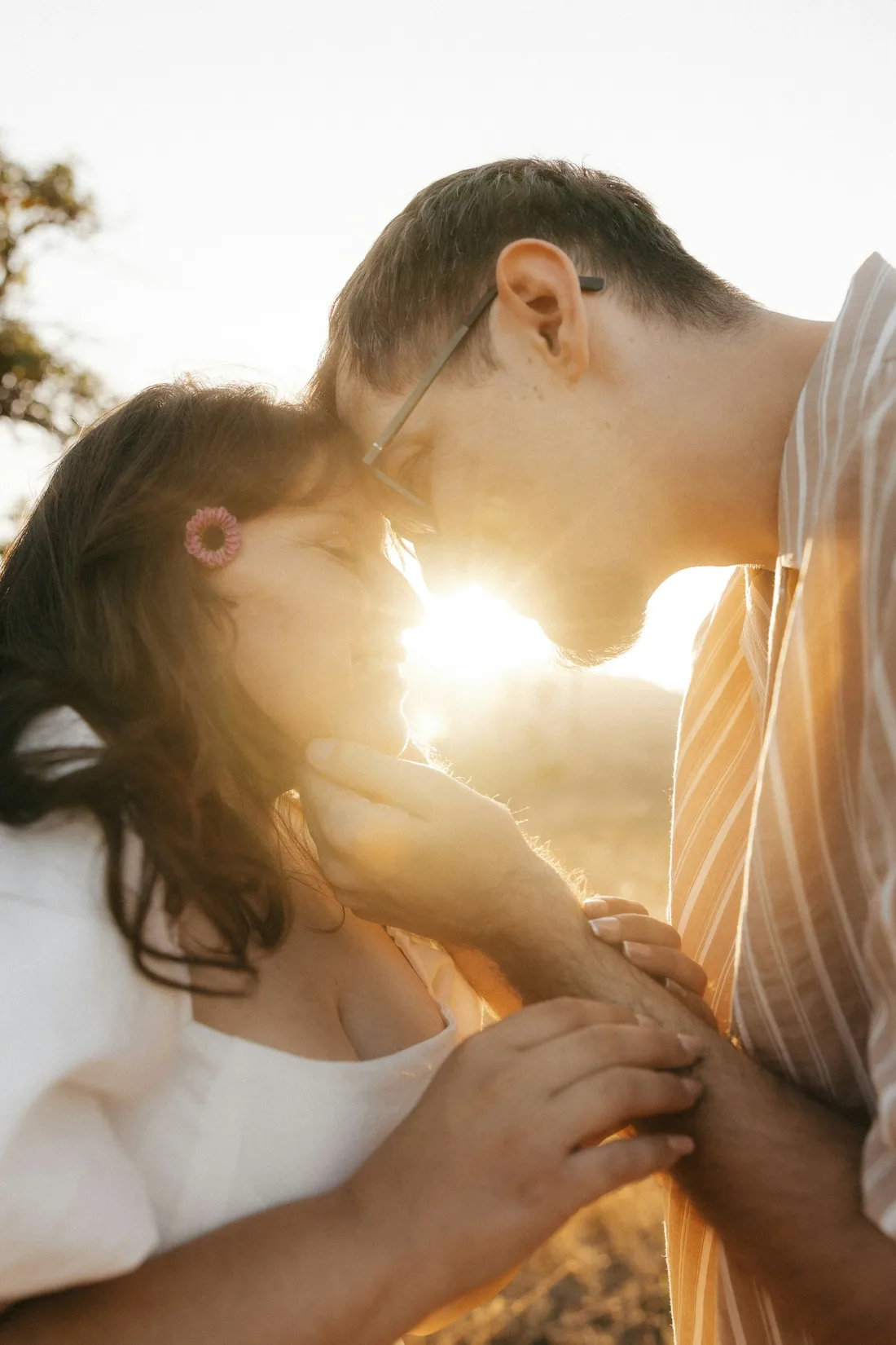 A couple laughing close together in golden evening light